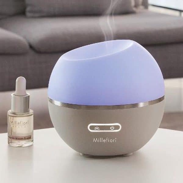 Aromatherapie diffuser en essentiële olie op een salontafel, ontspanning en wellness cadeau.